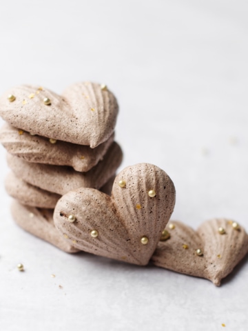 Stack of heart shaped chocolate meringues with gold sprinkles