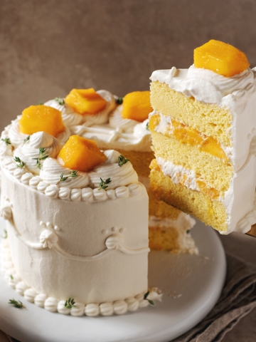 A slice of mango chiffon cake lifted from the cake with a cake server.