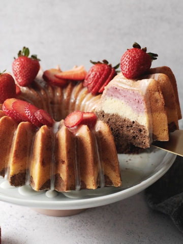 Lifting a slice of neapolitan bundt cake to show layers