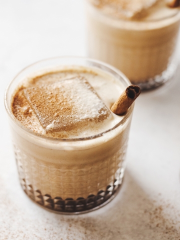Close up of pumpkin spice white russian cocktails and large ice cubes