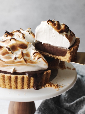 Piece of s'mores tart lifted away from the entire tart