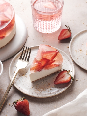 A slice of strawberry jelly cheesecake cut from the cake