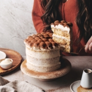 Lifting a slice of tiramisu layer cake with serving knife