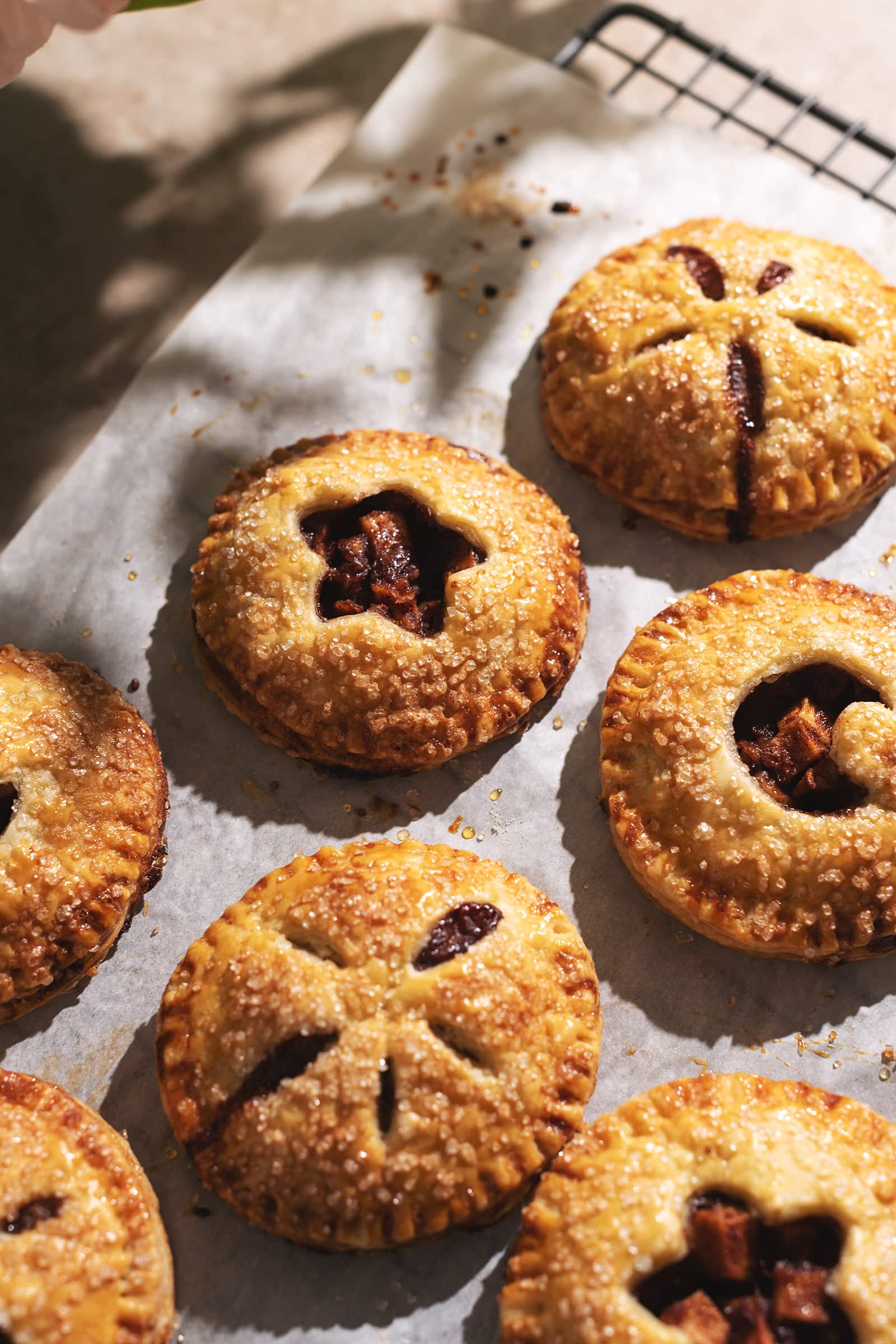 Apple hand pies scattered on parchment paper.