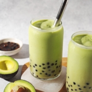 Glass of avocado boba with metal straw.