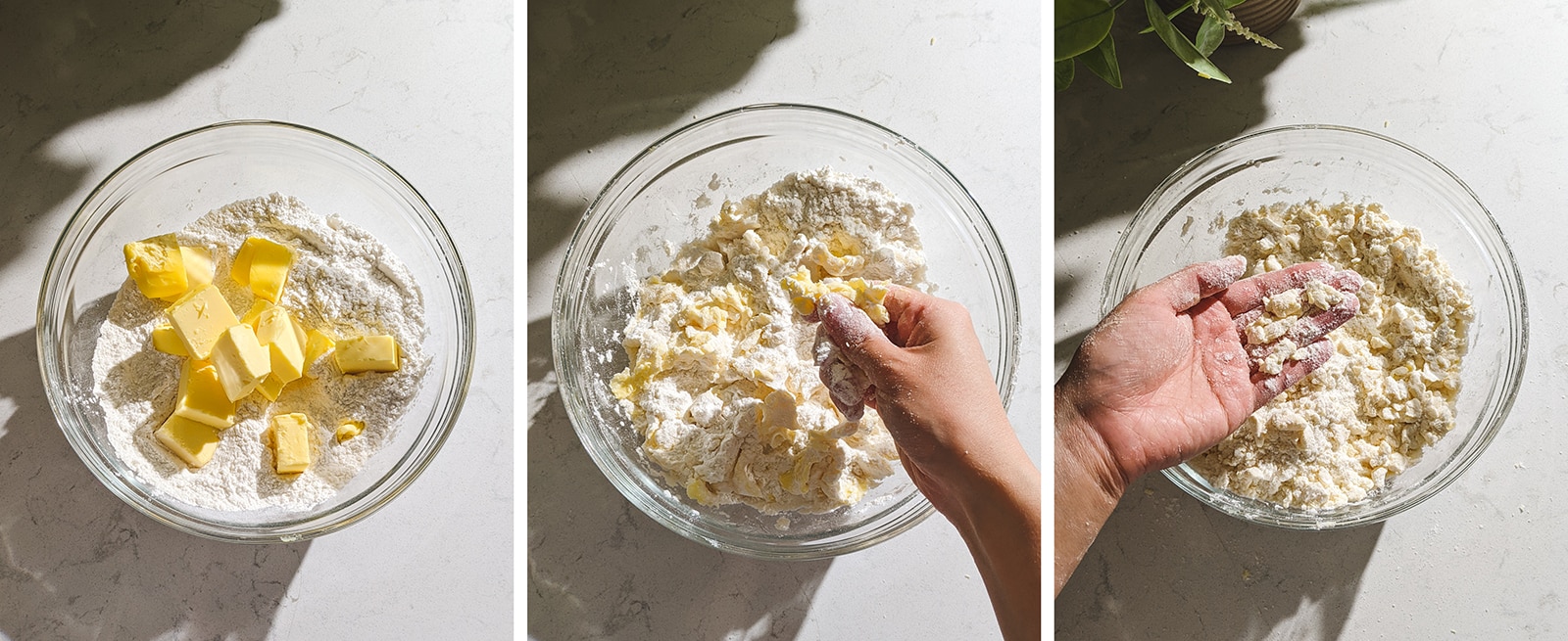 Using hands to break butter into smaller pieces over a bowl of flour.