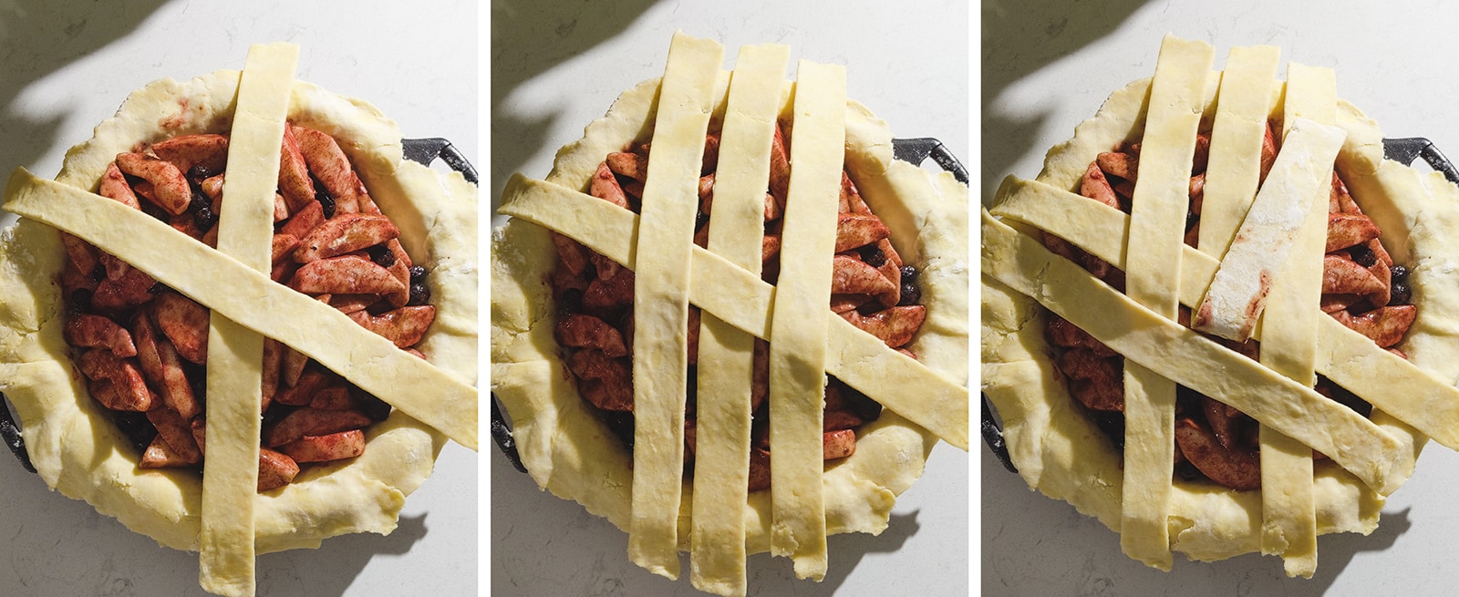 Placing down strips of dough on a pie.