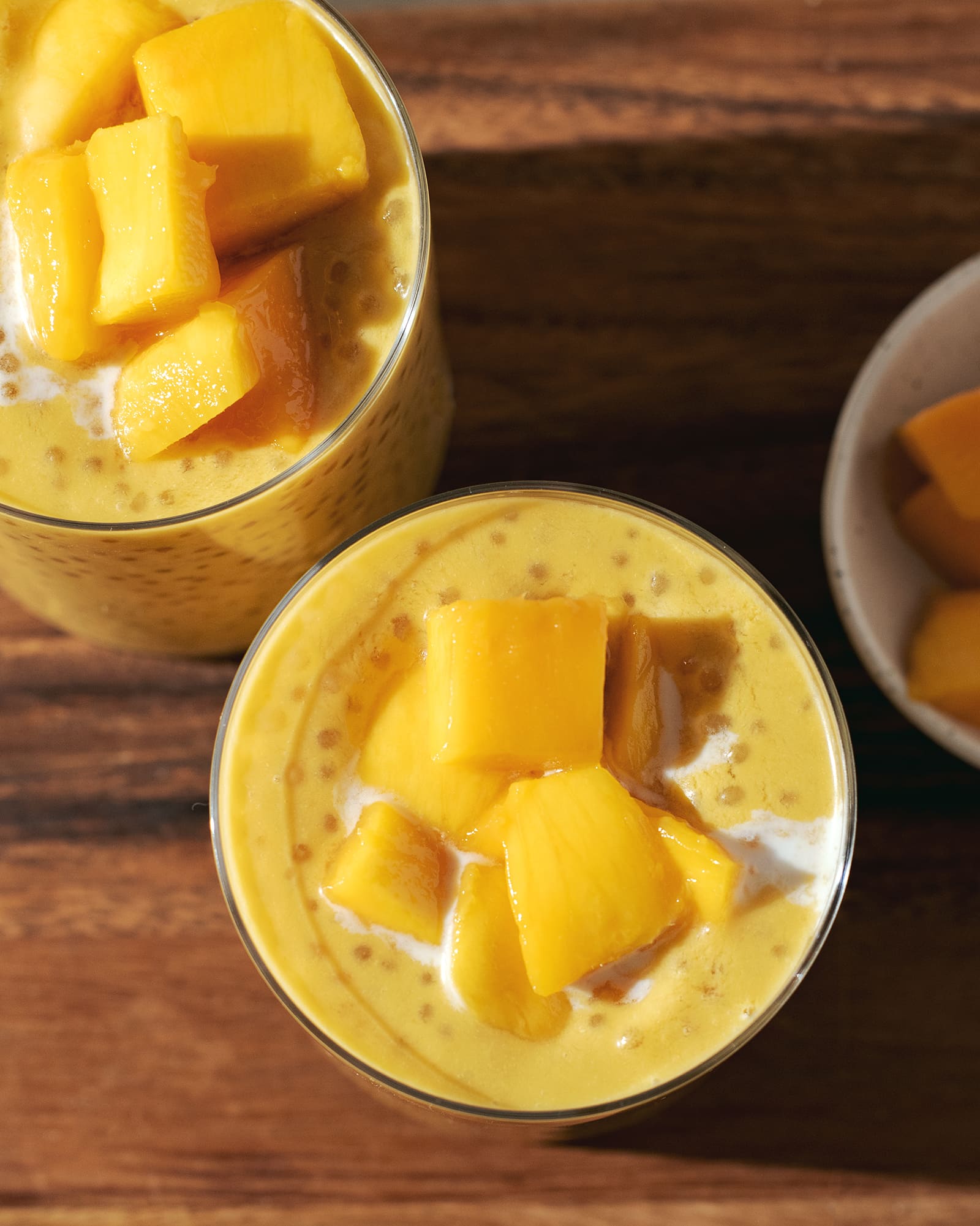 Overheard view of fresh mango chunks on top of mango sago.