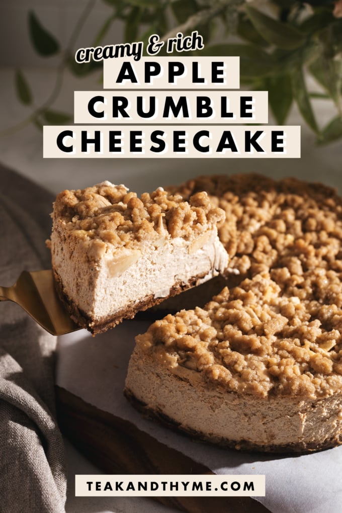 A slice of apple crumble cheesecake being lifted above the cake.