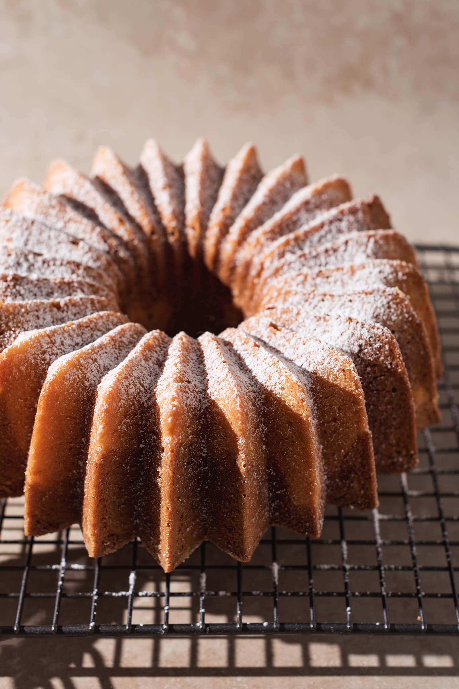 Bundt cake with ridged design sprinkled with powdered sugar.