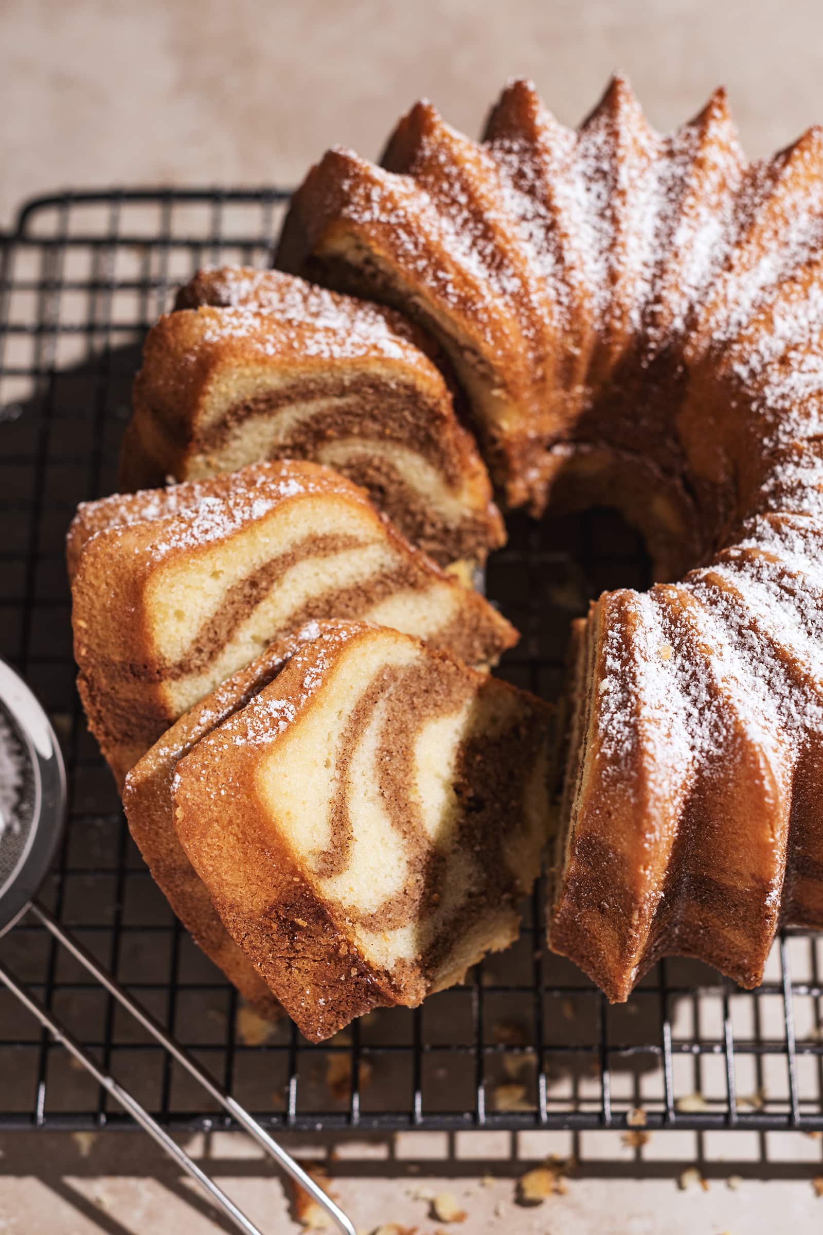 Slices of bundt cake with brown cinnamon swirls against vanilla cake.