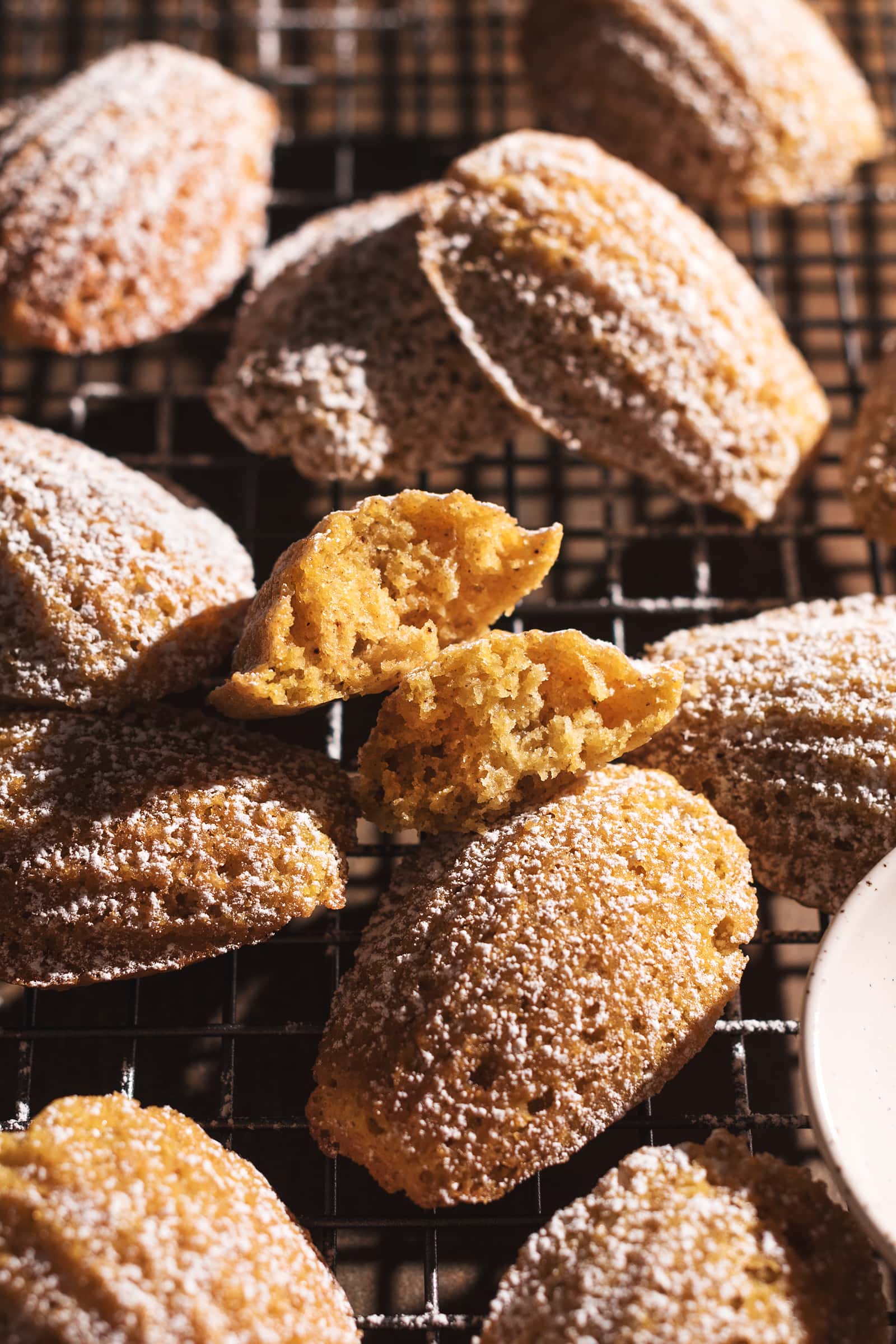 A pumpkin madeleine split in half to show the fluffy texture inside.