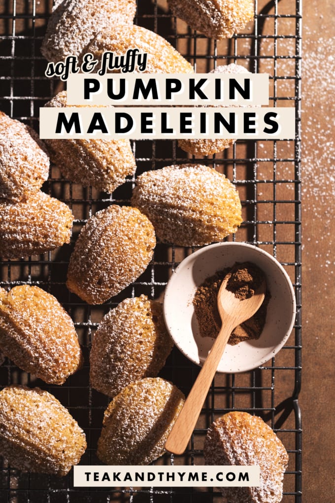 Pumpkin madeleines scattered on a wire rack with a small bowl of pumpkin pie spice.