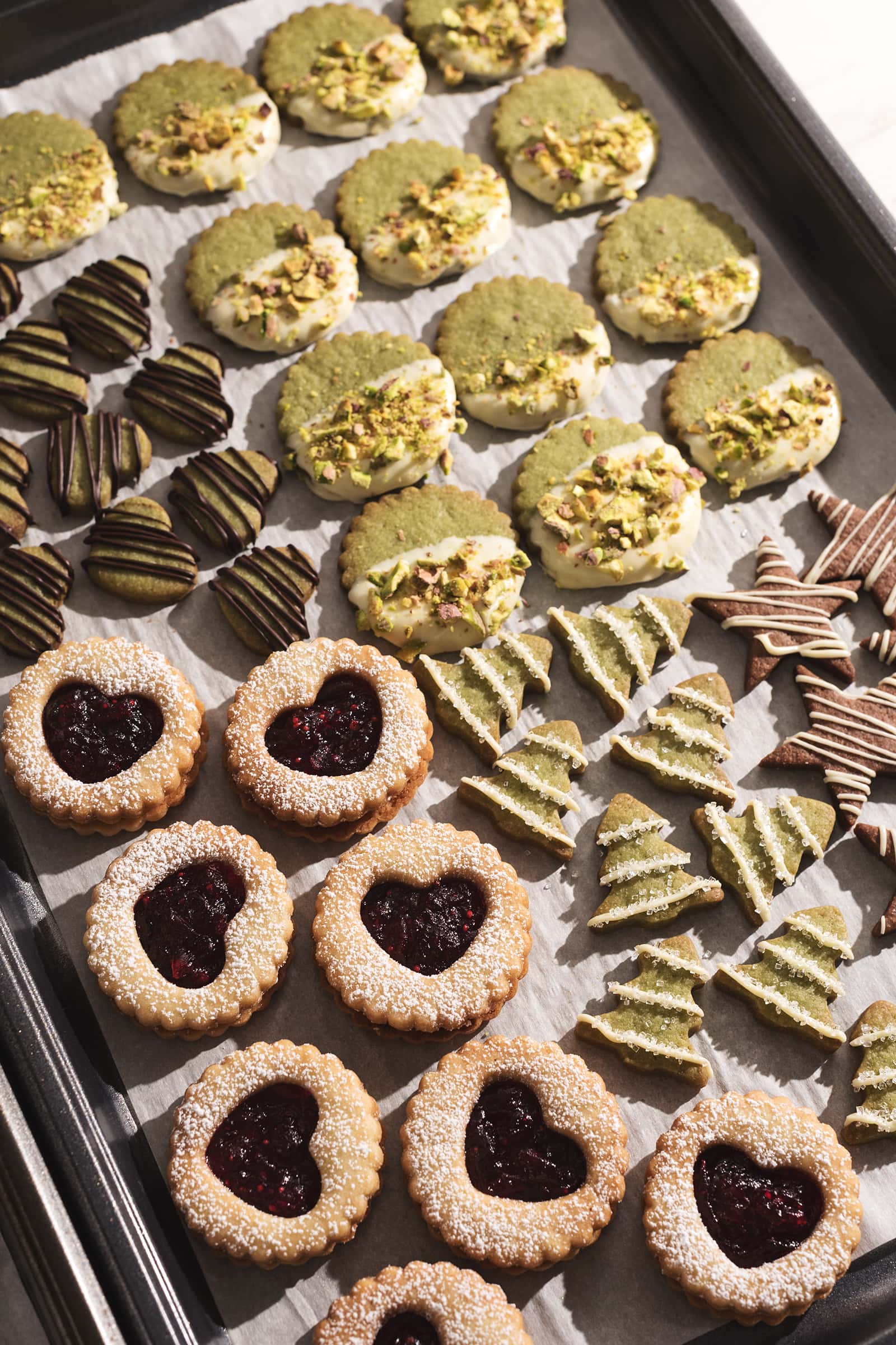 Matcha and cranberry butter cookie sandwiches on a baking tray.