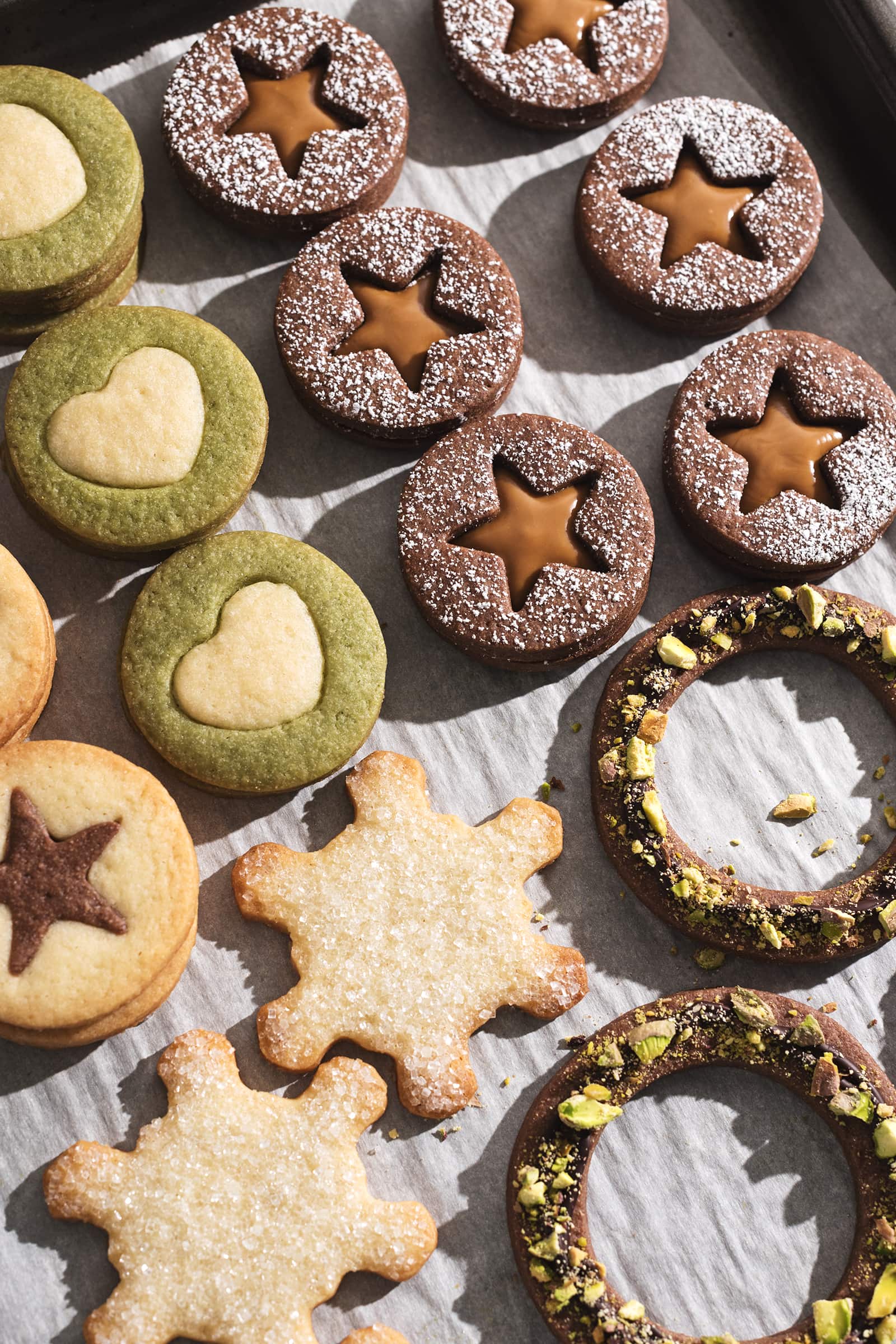 Butter cookies with star, heart, snowflake, and wreath cutouts.