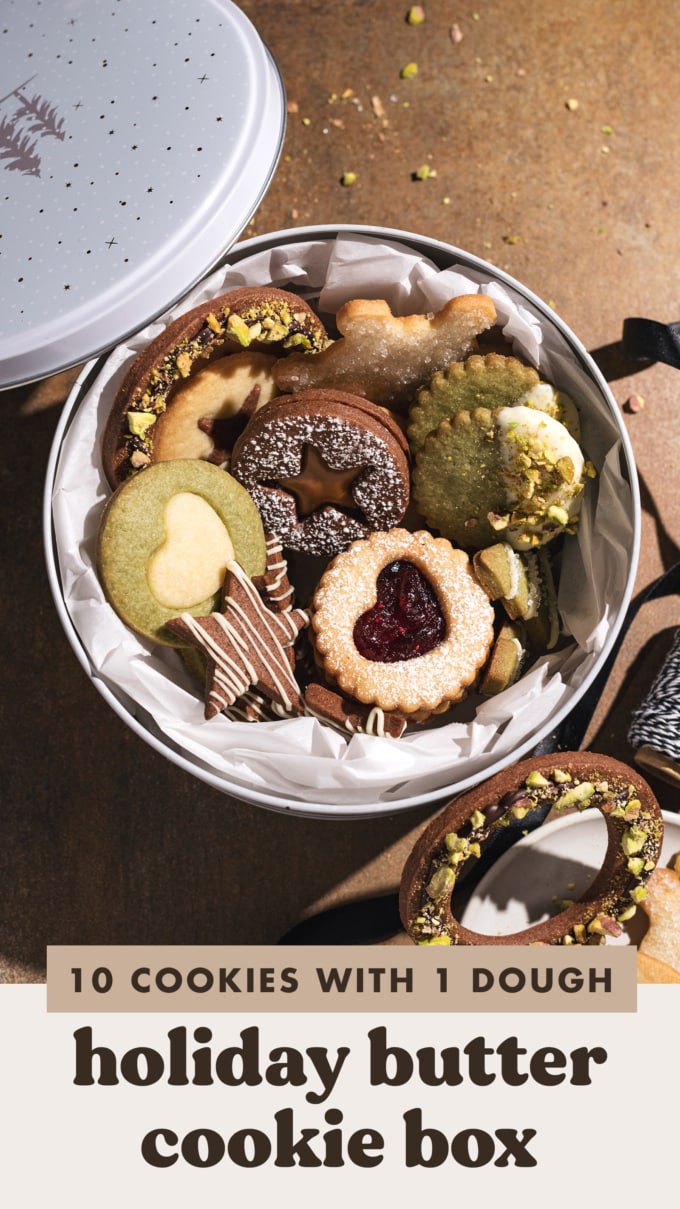 Assorted butter cookies in a round tin with cookies scattered around it.