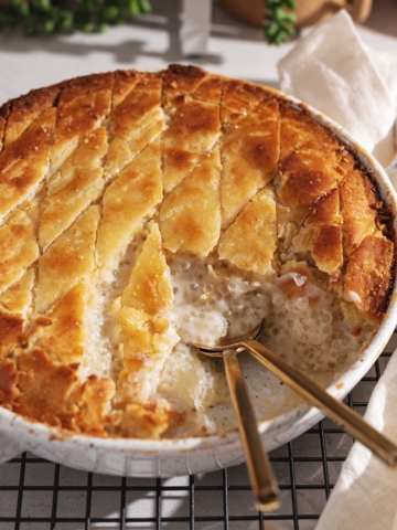 A scoop taken out of a baked tapioca pudding to show the sago pearls inside.