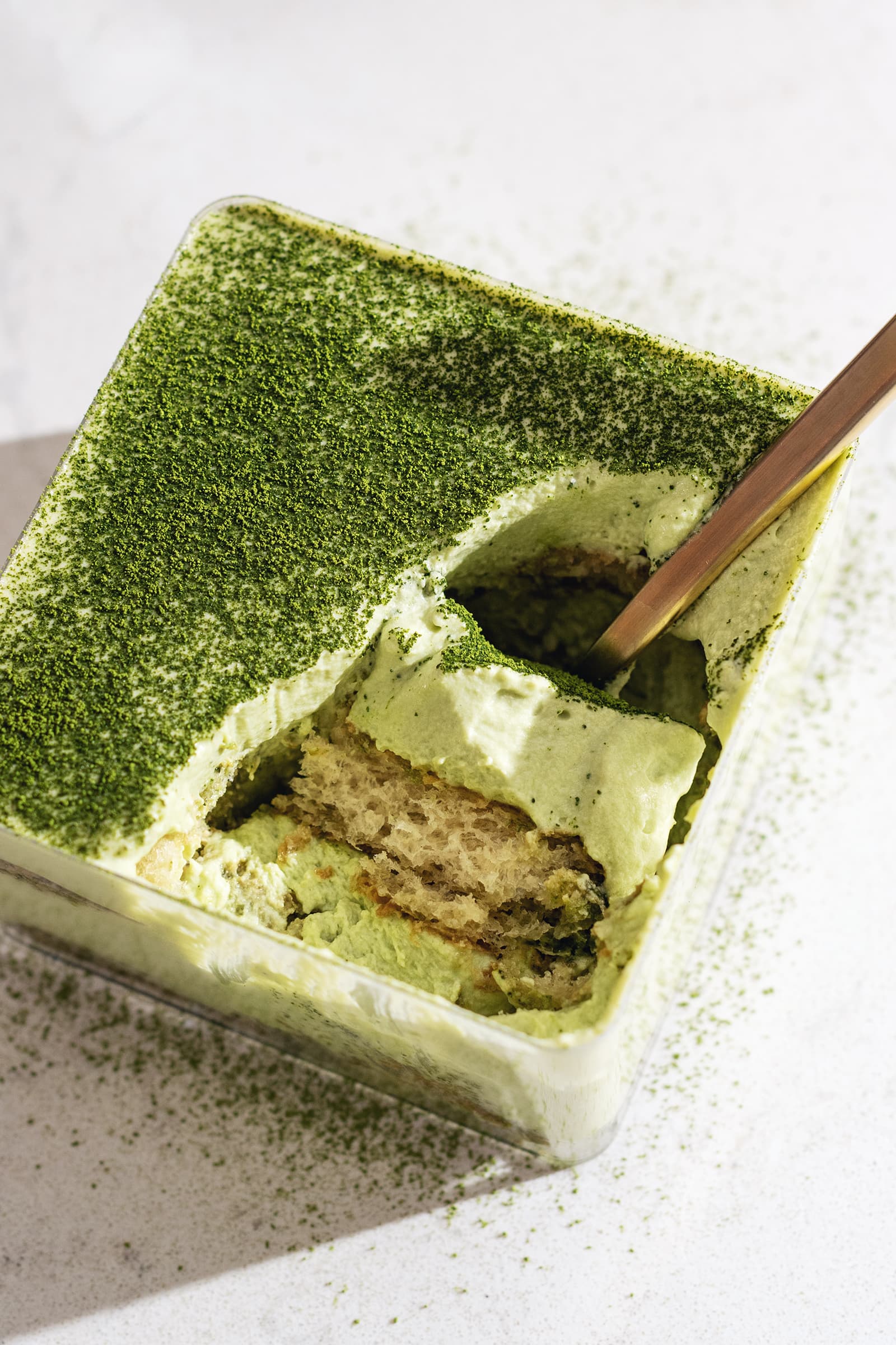 A scoop of matcha tiramisu resting in its container.