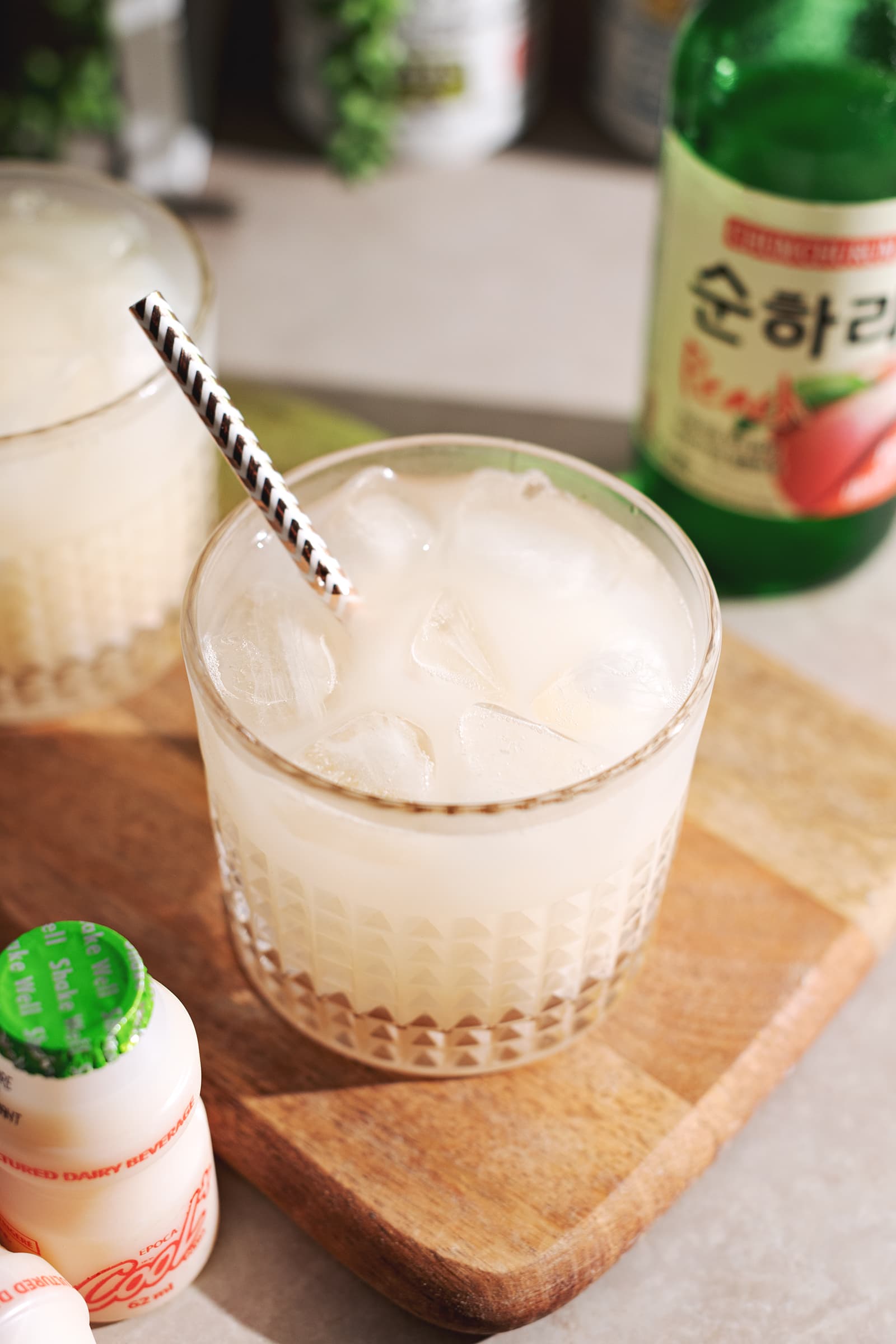 Milky white soju yakult cocktail in a highball glass.