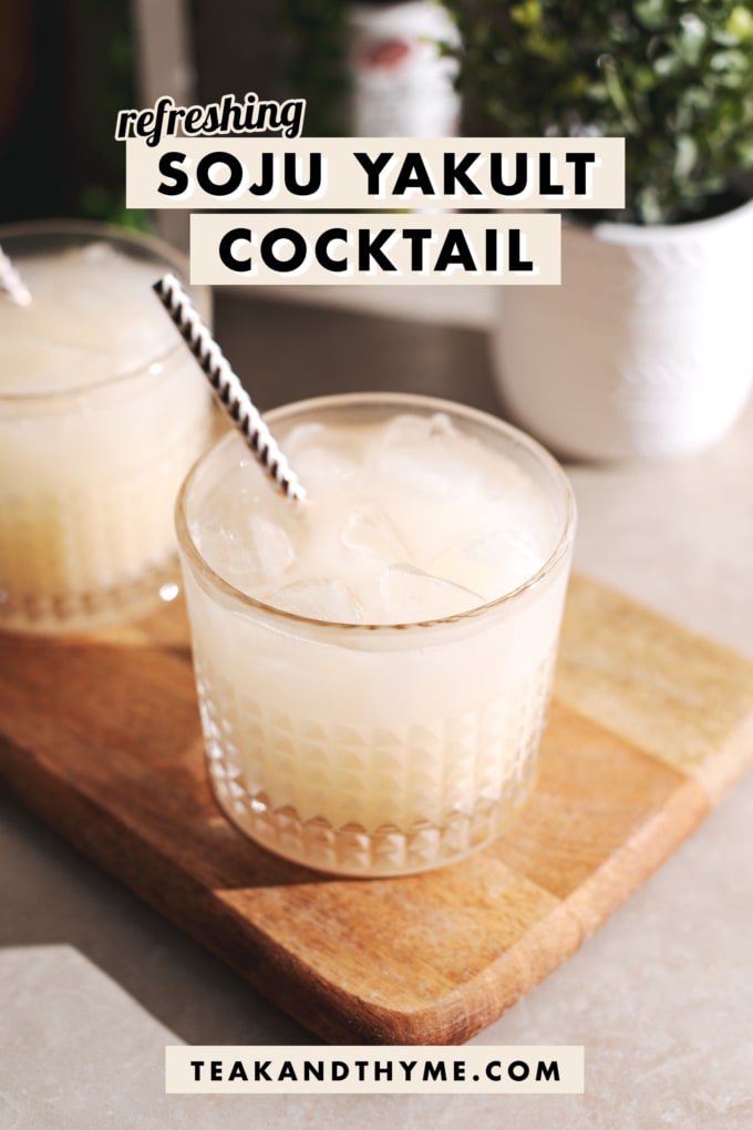 Milky white cocktail in a highball glass on a wooden platter.