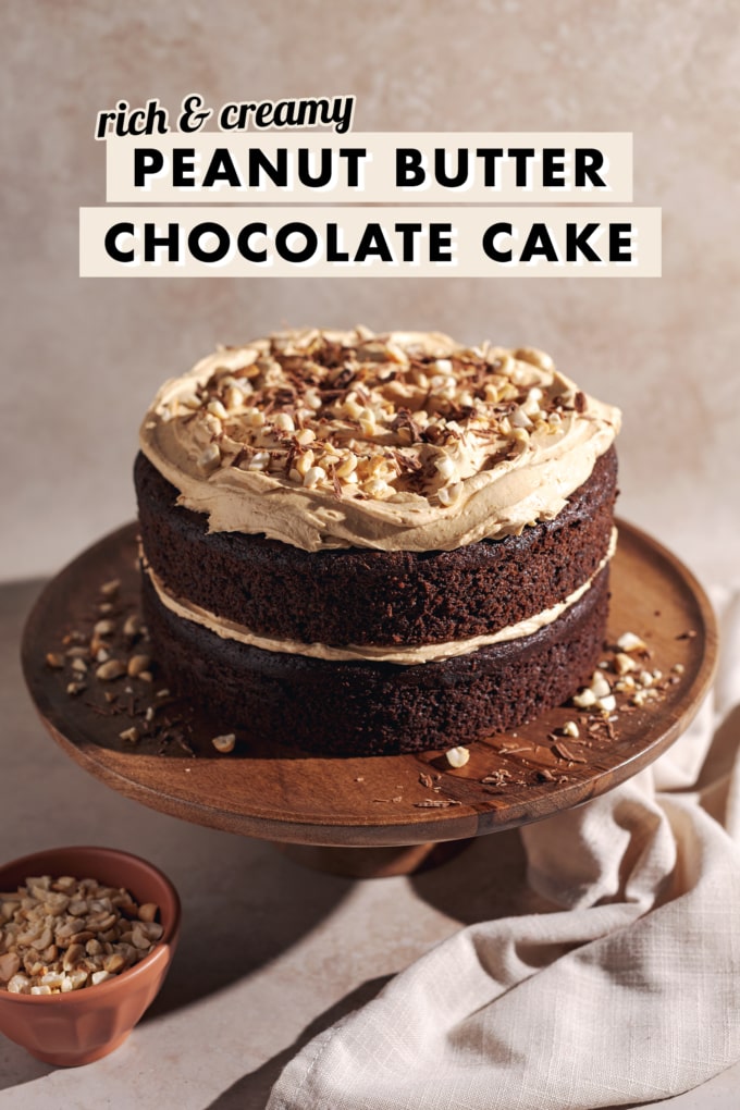 Two layer chocolate cake with peanut butter frosting on a wooden cake stand.