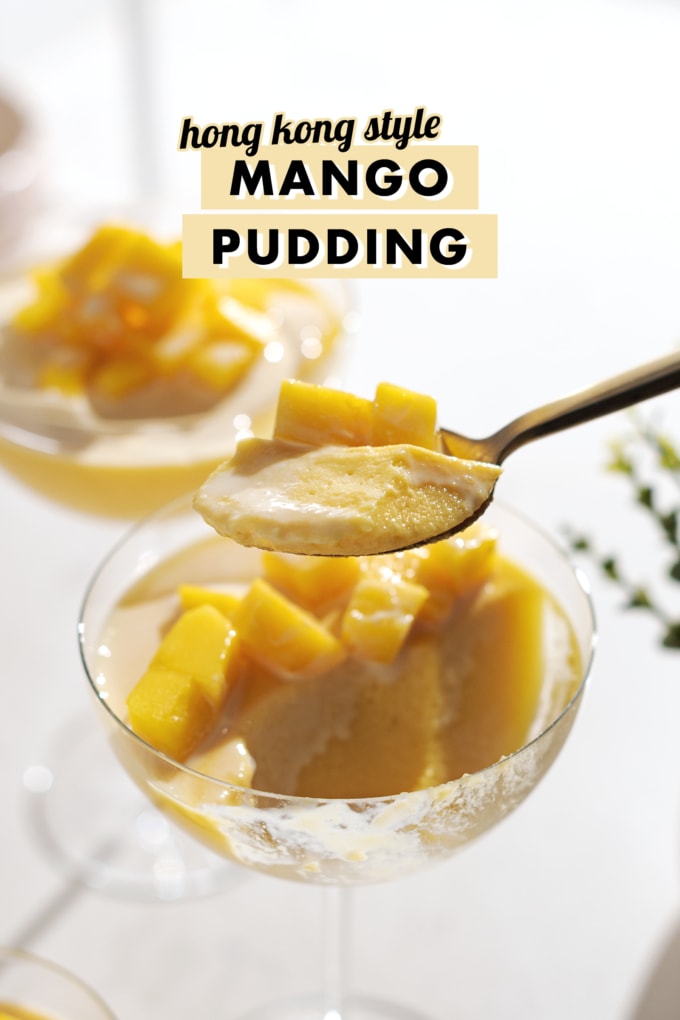 A spoonful of mango pudding being lifted from a glass cup.