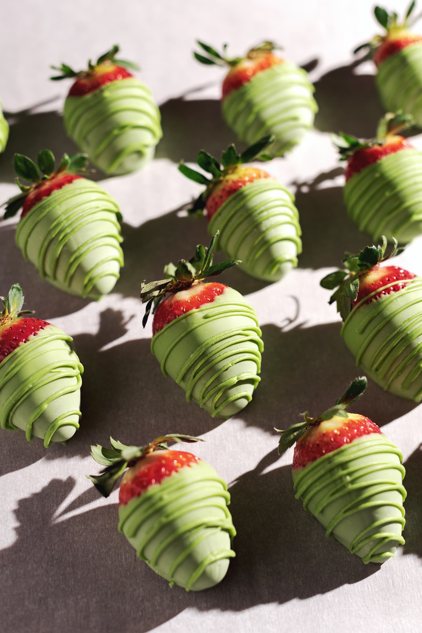 Matcha-covered strawberries lined up in rows.