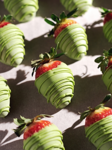 Matcha-covered strawberries lined up in rows.