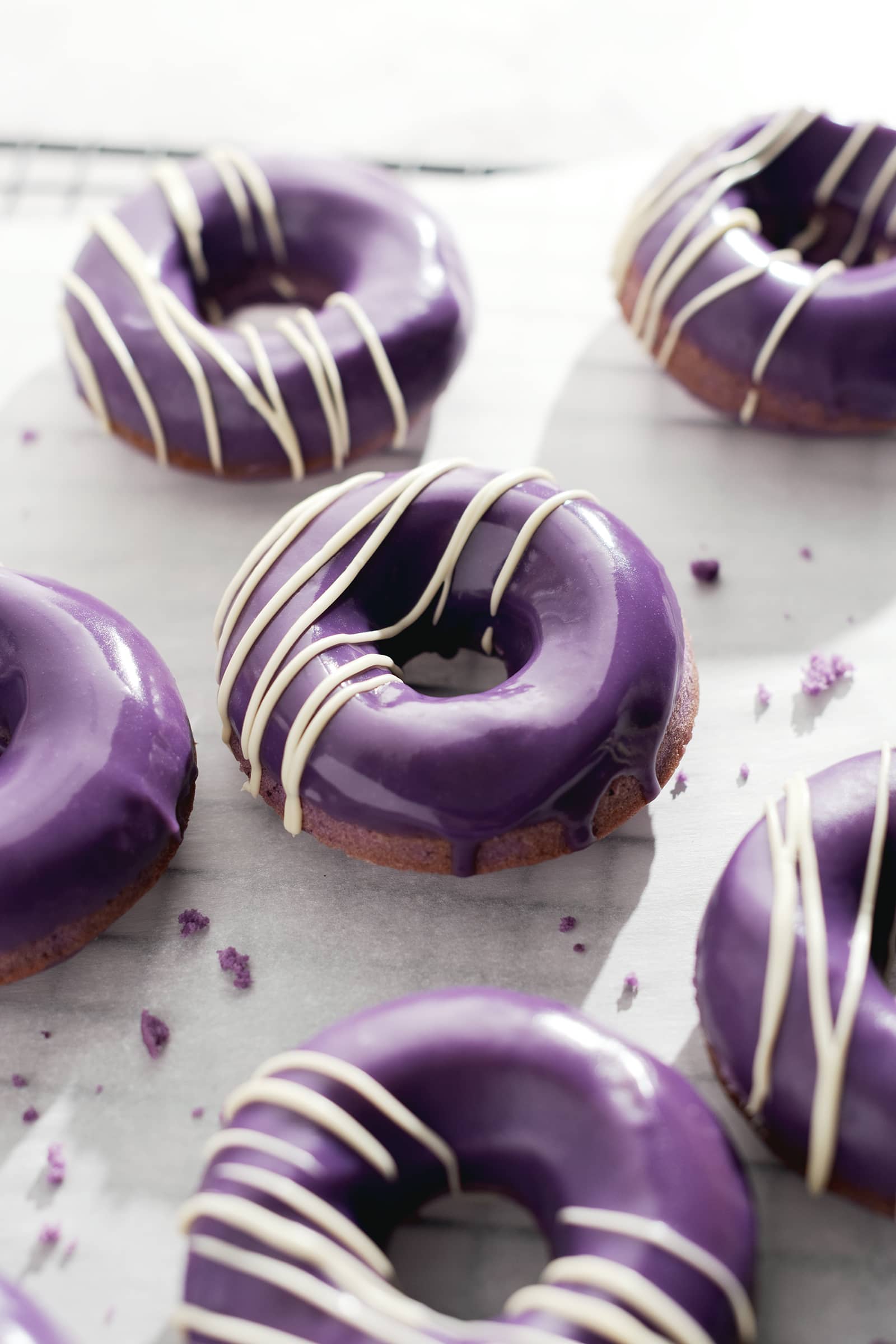 Ube donut with purple glaze dripping down the side.