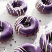 Ube donut with purple glaze dripping down the side.