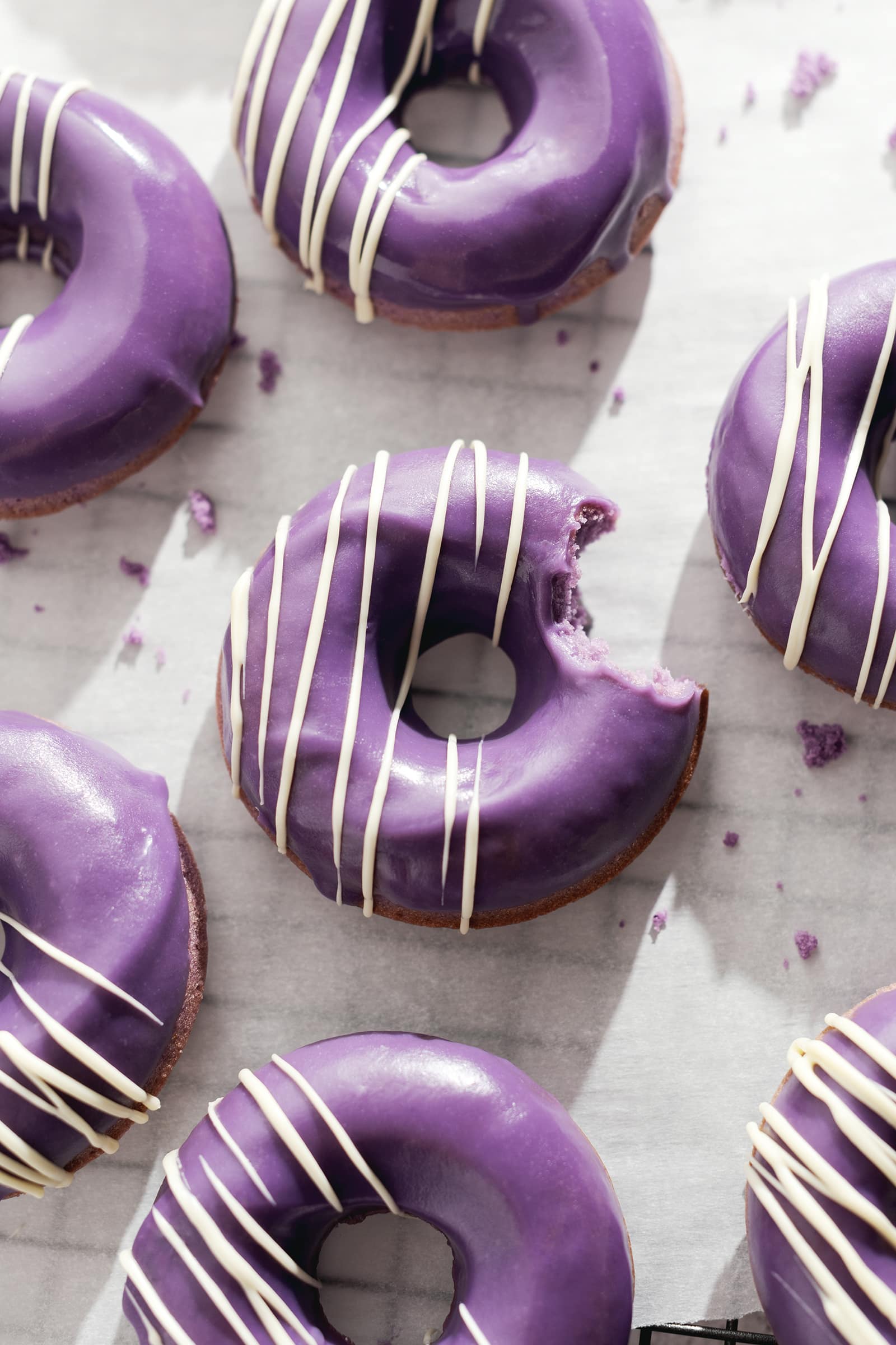 Donut with a bite taken out of it surrounded by other donuts.