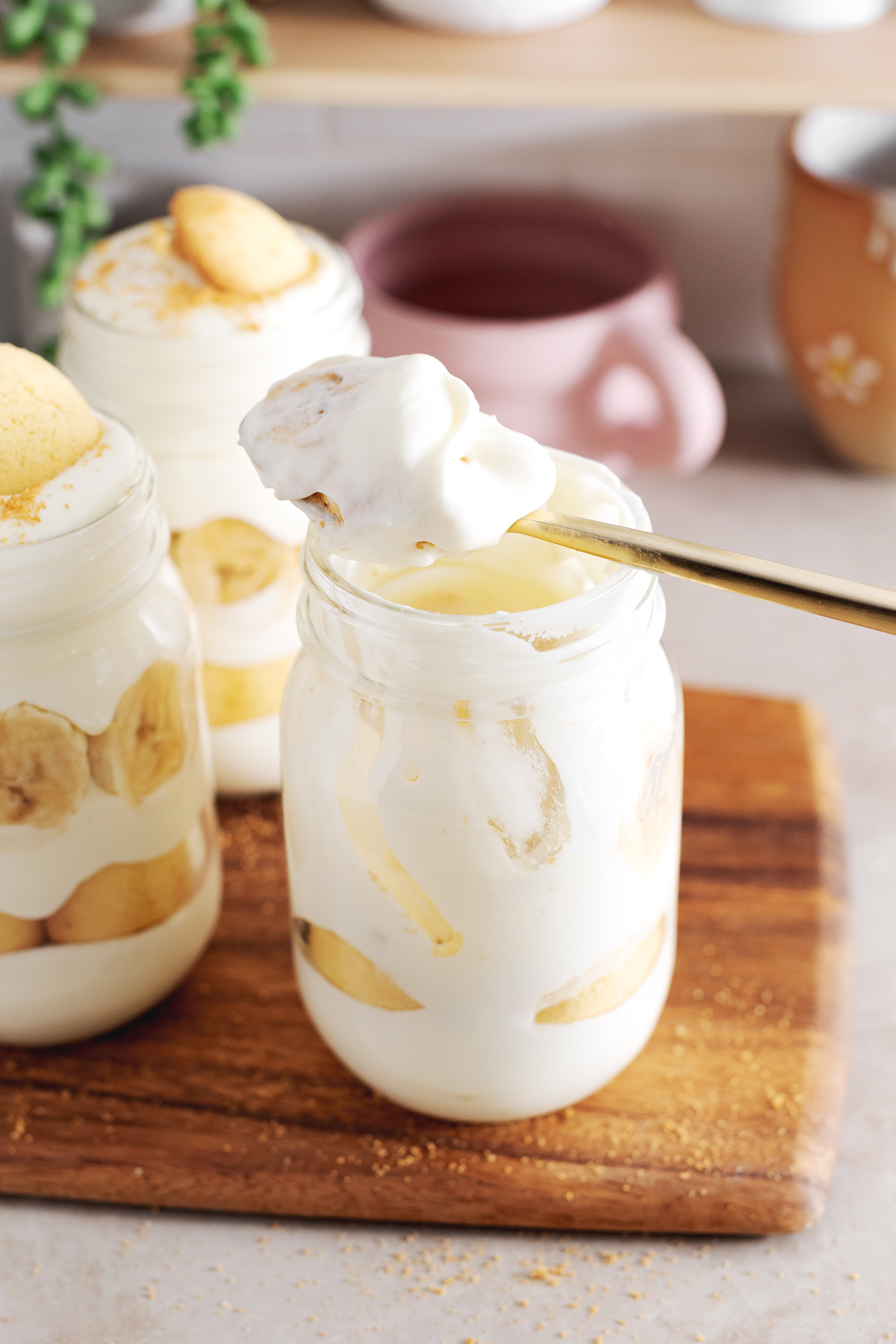Spoonful of banana pudding rest on top of jar.