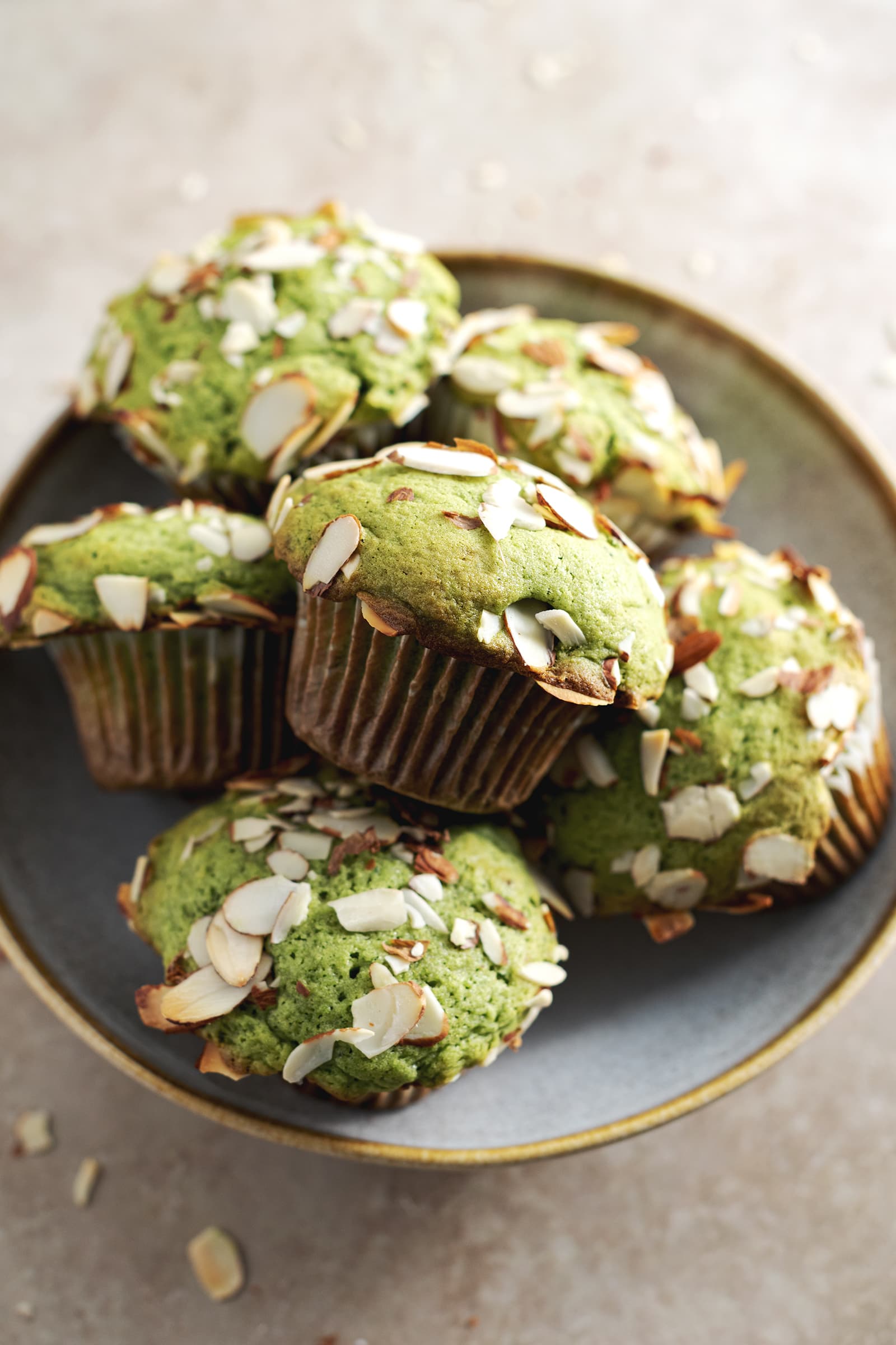 A stack of matcha muffins sitting in a bowl.