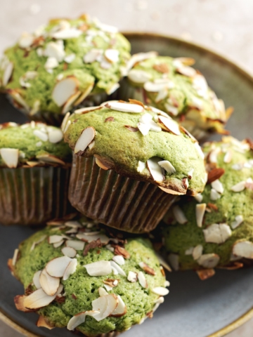 A stack of matcha muffins sitting in a bowl.
