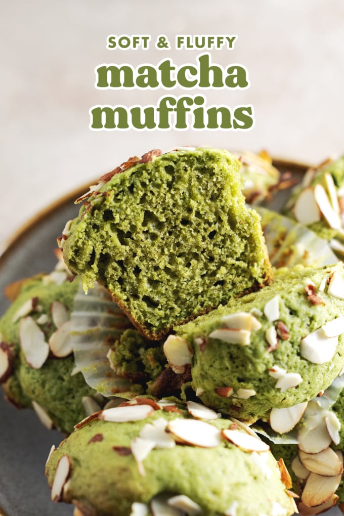A matcha muffin cut in half to show texture sitting on top of pile of muffins.