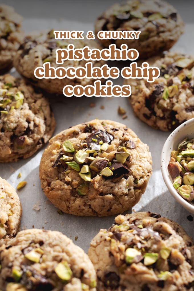 Pistachio chocolate chip cookie surrounded by many other cookies on a baking tray.
