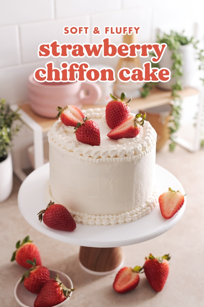 Strawberry chiffon cake on cake stand on kitchen counter.