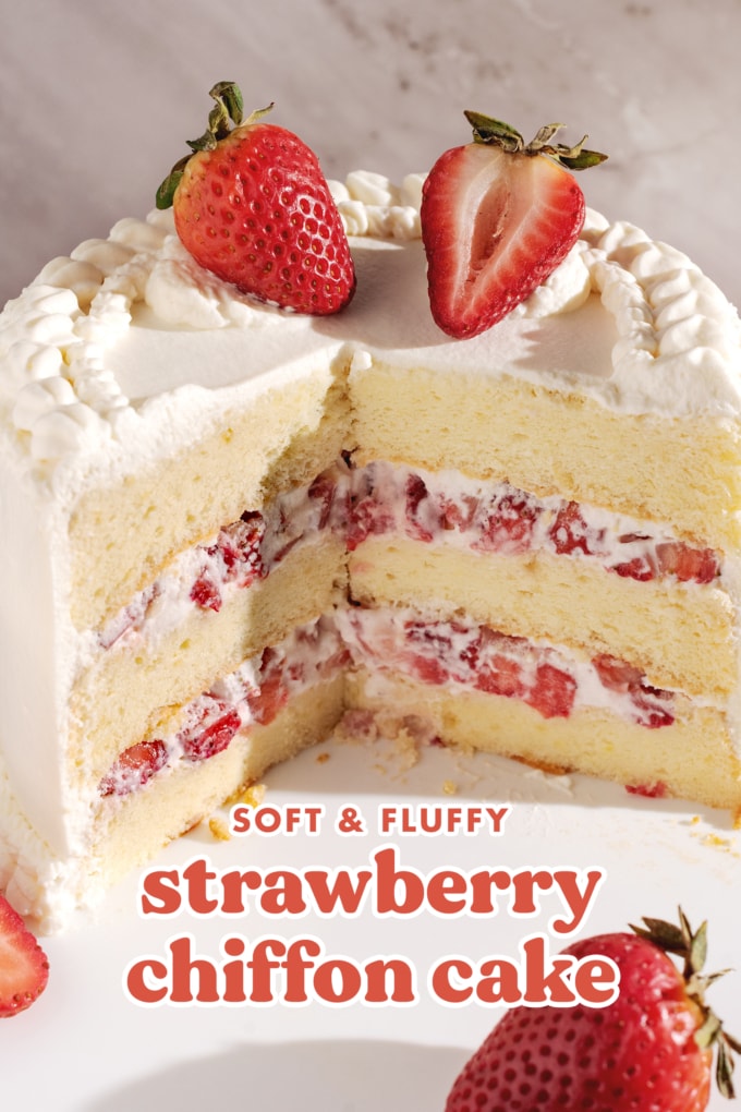 Cross-section of cake showing layers of chiffon cake, whipped cream, and strawberries inside.