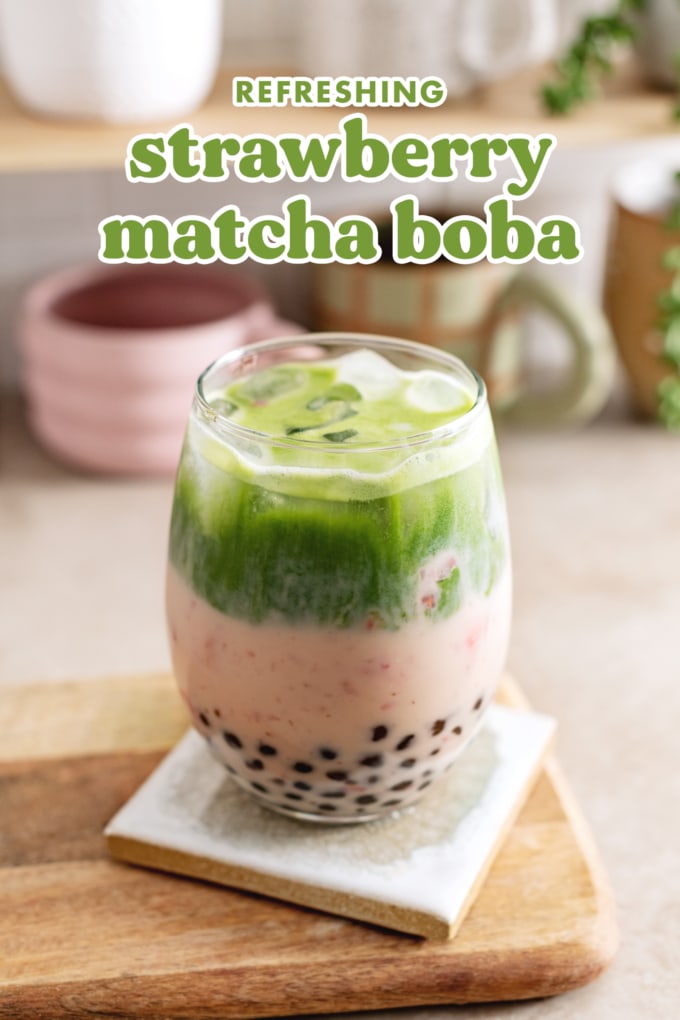 Glass filled with boba pearls, strawberry milk, and matcha split into two layers.