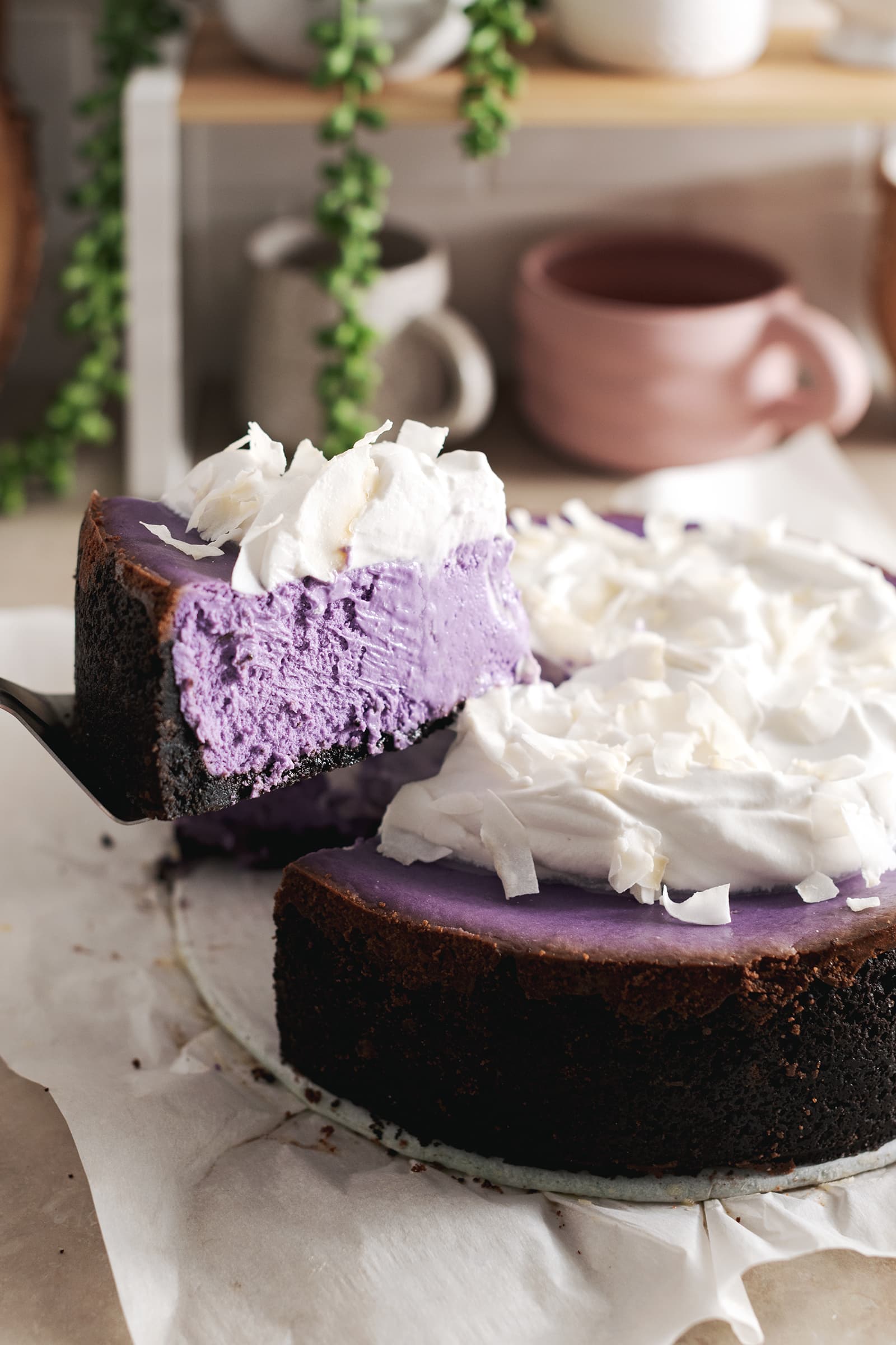 A slice of ube cheesecake lifted from the rest of the cheesecake.
