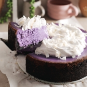 A slice of ube cheesecake lifted from the rest of the cheesecake.
