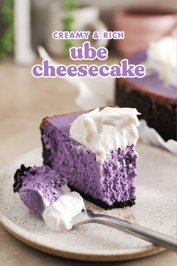 A slice of ube cheesecake with a forkful of cheesecake laying next to it.