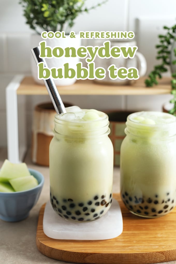 Two glasses of honeydew bubble tea on a wooden platter.