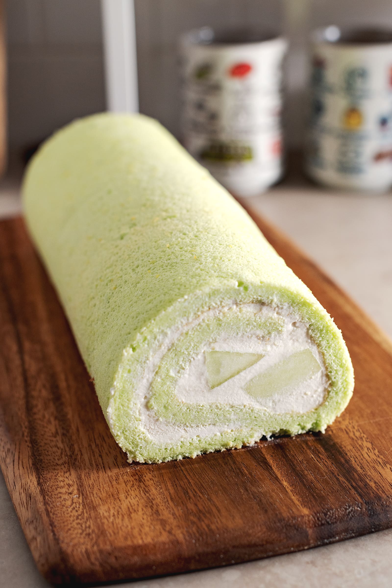 A whole roll cake on a wooden platter.