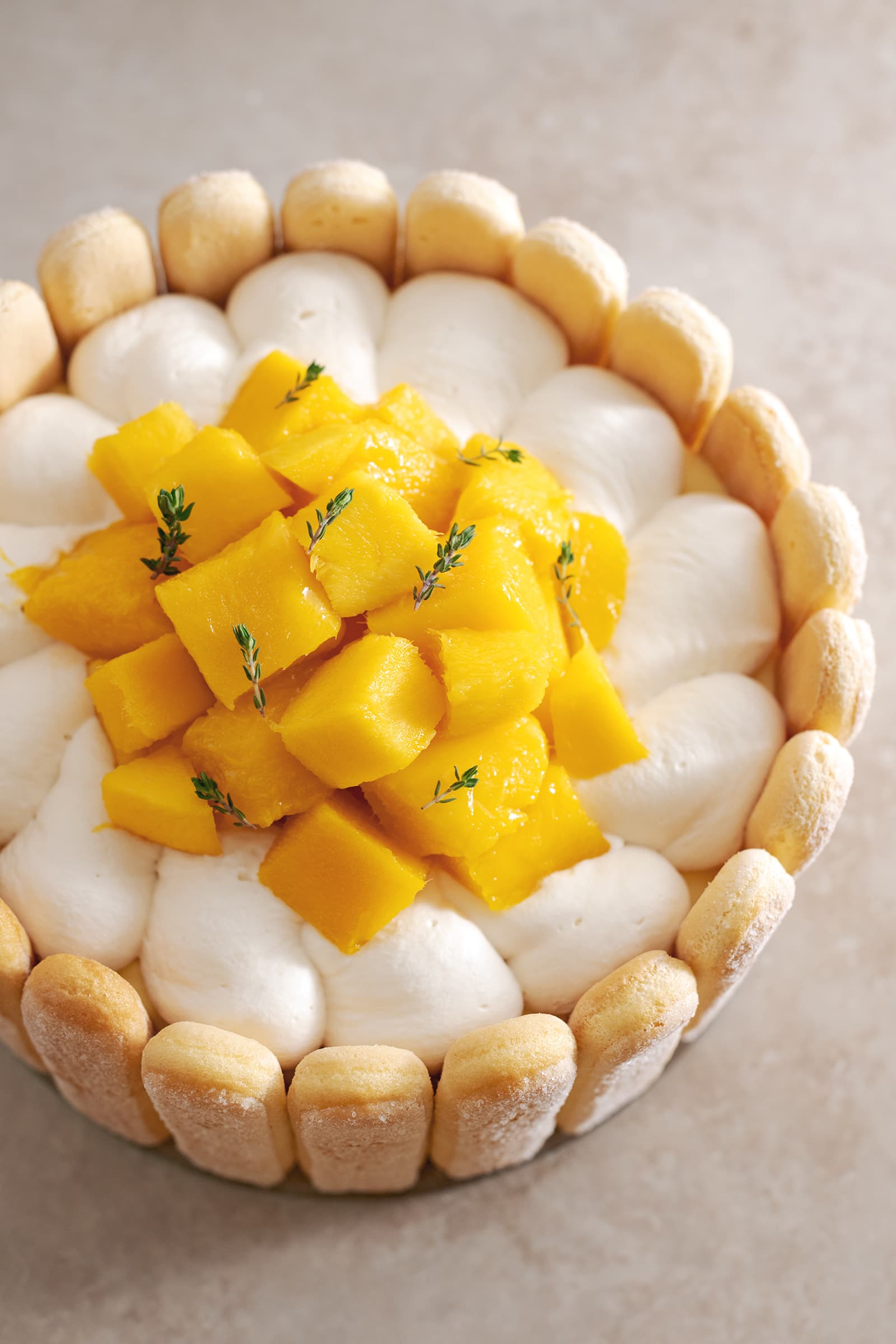 Top down view of cake showing whipped cream and pile of mango chunks on top.