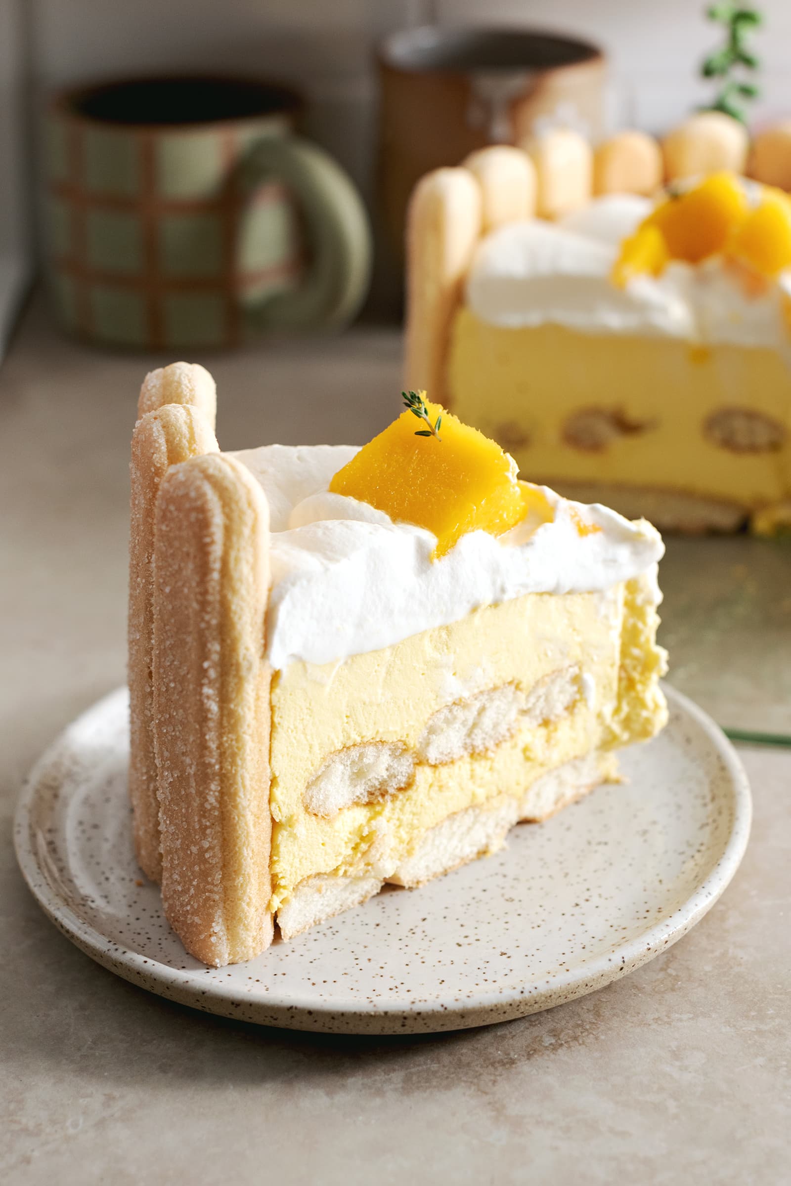 A slice of mango charlotte cake on a plate.
