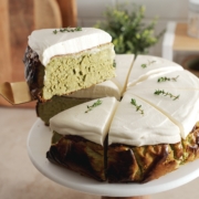 Lifting a slice of matcha basque cheesecake from the rest of the cake.