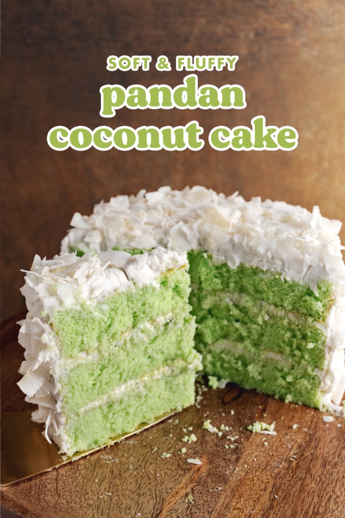 A slice of pandan coconut cake in front of half of a cake in the background.
