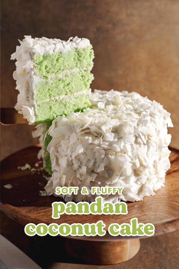 A slice of pandan coconut cake being lifted from the whole cake with a cake server.