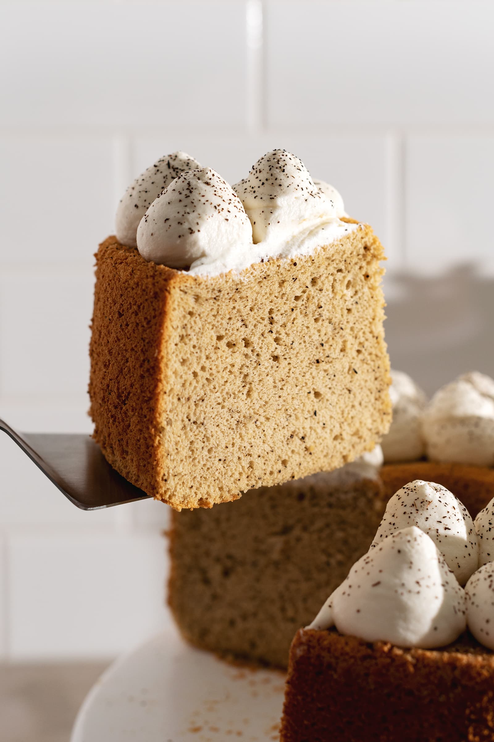Holding a slice of cake on a cake server.